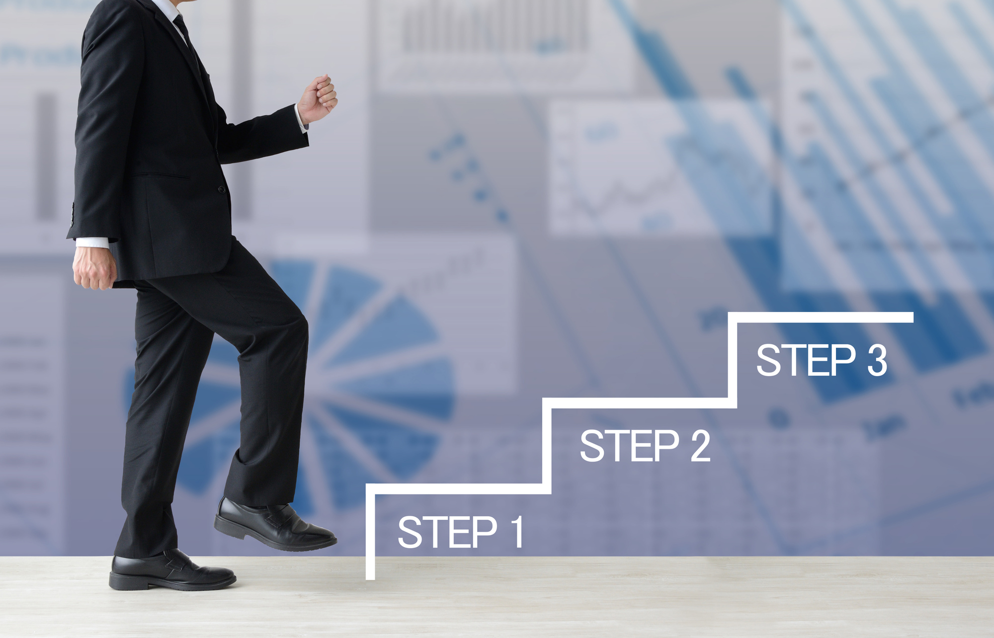 STEP1、STEP2、STEP3と書かれた階段のイラストを上ろうとするスーツ姿の男性